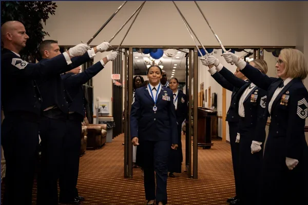 Airmen form a saber arch for an honoree at a military recognition ceremony